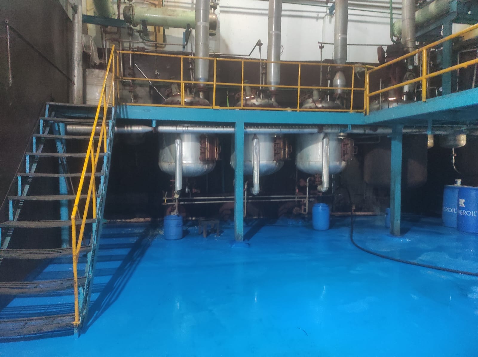 Extraction vessels and pipework on a mezzanine platform with safety railings